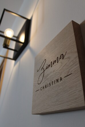 Una placa de madera con los nombres 'Zimmer' y 'Christina' en una pared.