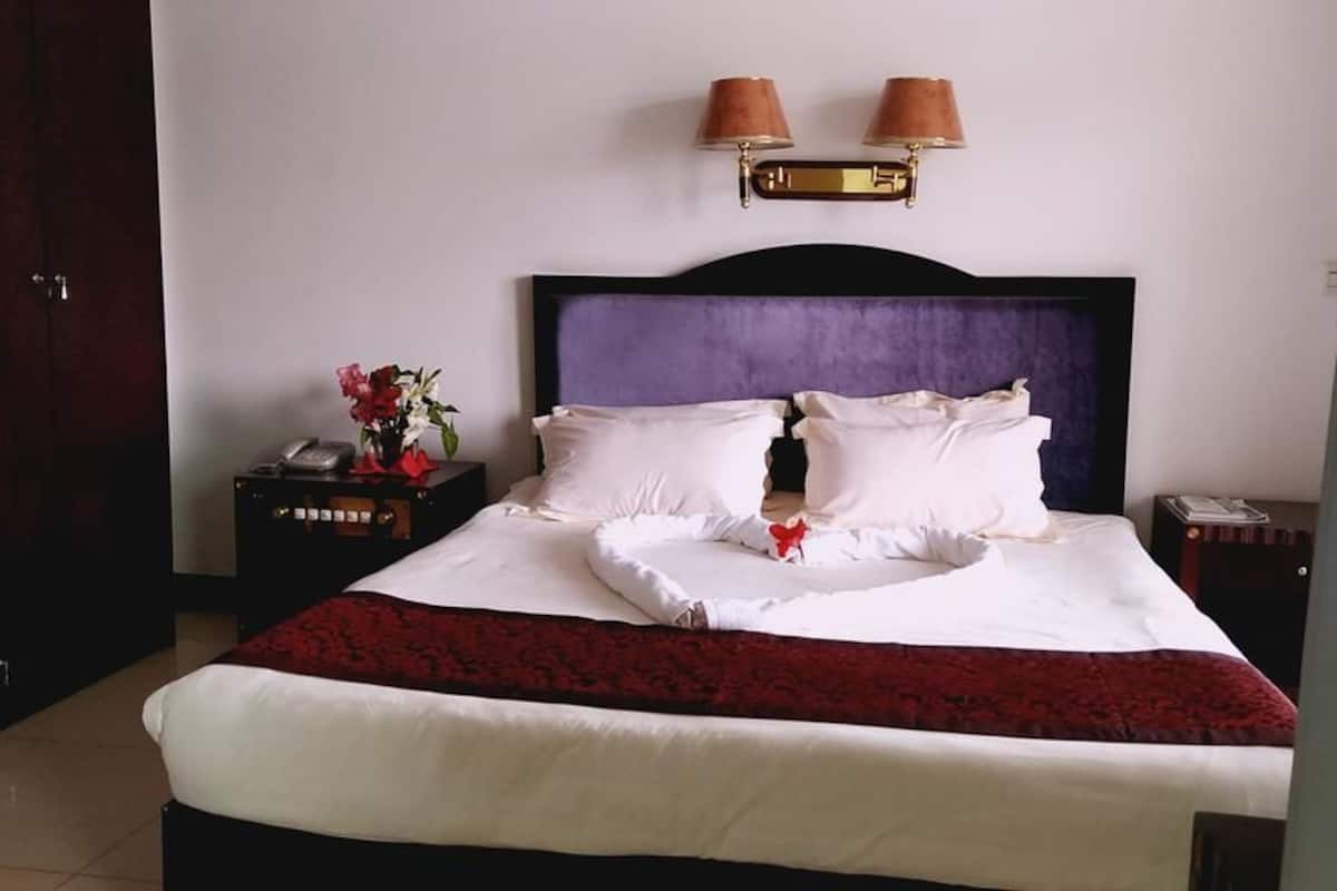 Deluxe suite, 1 kingsize bed, uitzicht op stad | Een minibar, een kluis op de kamer, een bureau, verduisterende gordijnen