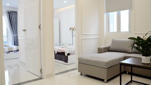 A modern living room with a sofa, a coffee table, and a potted plant. - Smiley Apartment 8 (Ho Chi Minh City)