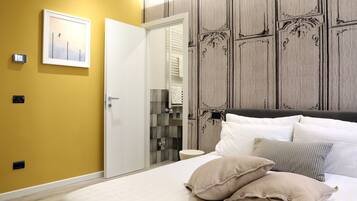 Une chambre d’hôtel avec un lit, des oreillers, une armoire et un miroir.