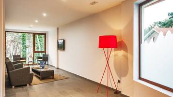 Een moderne woonkamer met een bank, een salontafel en een rode vloerlamp.