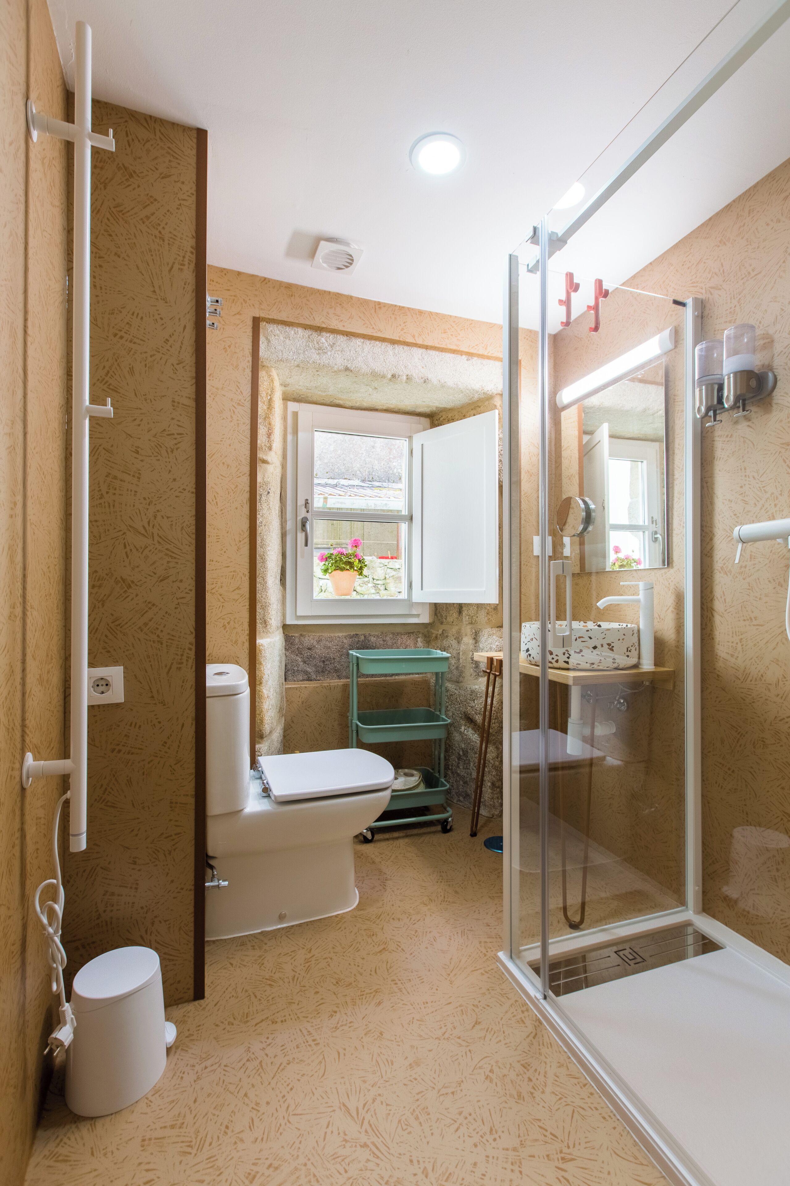 A bathroom with a toilet, shower, and sink.