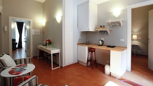 Un espacio habitable compacto con comedor, kitchenette y una pequeña zona de estar.