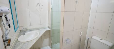 Un baño con lavamanos, inodoro y cabina de ducha de vidrio.