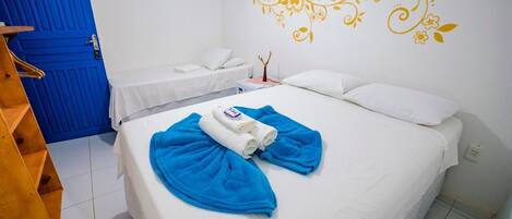Une chambre d’hôtel avec un lit, une porte bleue et un élément de décoration au mur.