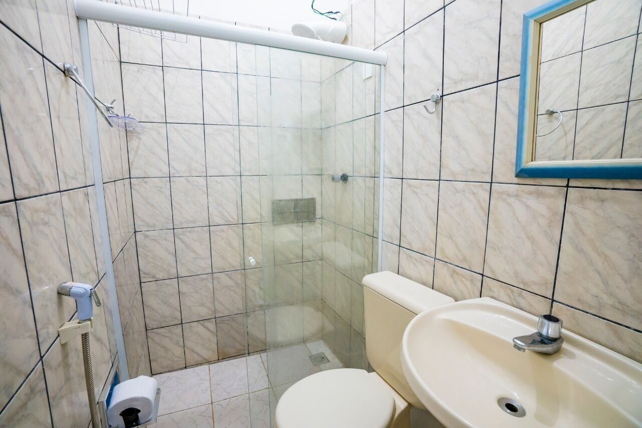 Un baño con ducha de vidrio, inodoro y lavamanos.