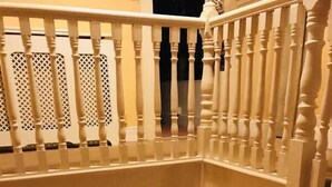 Una scala con balaustre bianche, un tavolino con candele e una lampada.