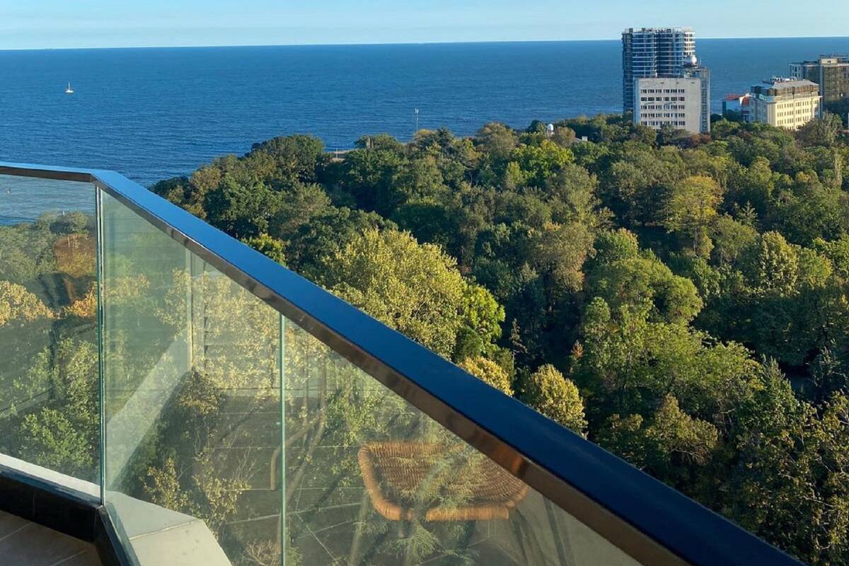 Ein Balkon mit freiem Blick auf das Meer und die umliegenden Gebäude.