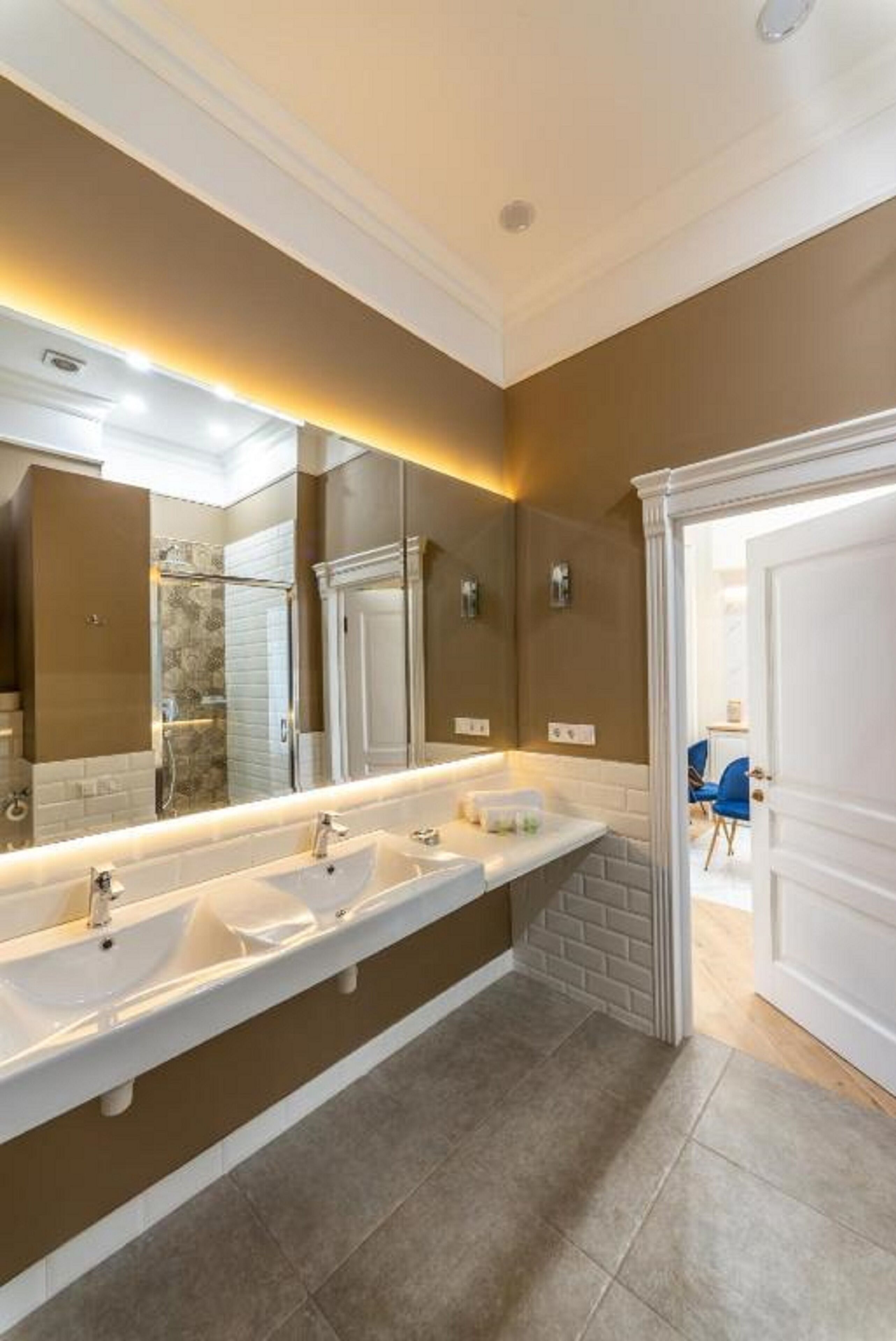 Un baño moderno con un tocador amplio, lavamanos dobles y un espejo grande.