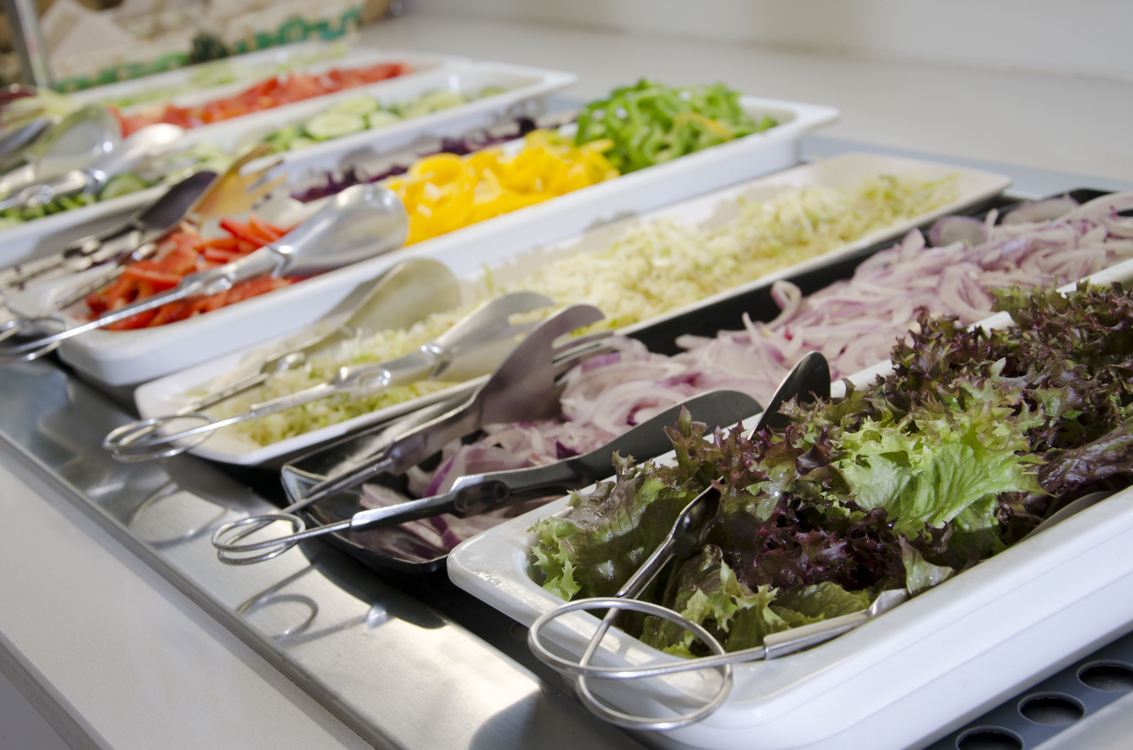 A buffet with various food items and utensils.