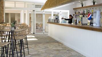 A bar area with a counter, seating, and a view of the outdoor patio.