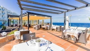 An outdoor dining area with tables and chairs, overlooking the sea. - Hotel Ereza Mar- Adults Only (Antigua)