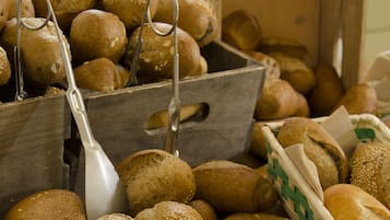 Variedad de panes expuestos en cestas de madera y un panera.