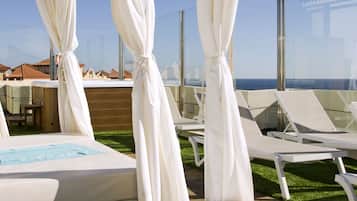 Terraza en la azotea con canopies blancos, sillones de descanso y zona de piscina.