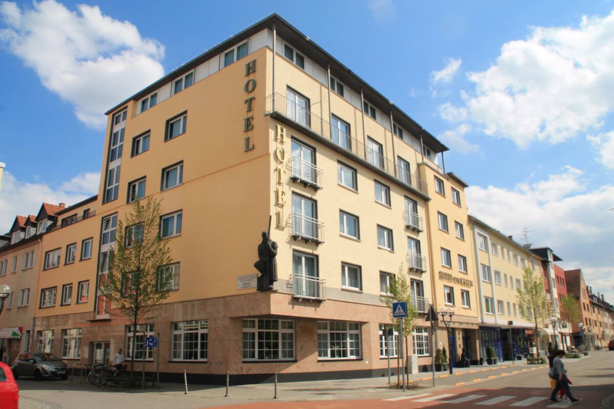 A multi-story hotel with a prominent "HOTEL" sign on the facade, featuring balconies and large windows.