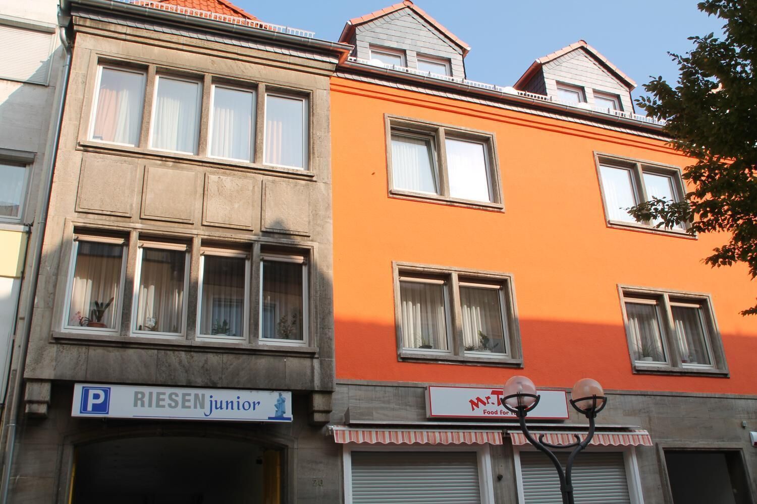 Un edificio con un letrero de 'Riesen junior' y un restaurante llamado 'Mr. T'.