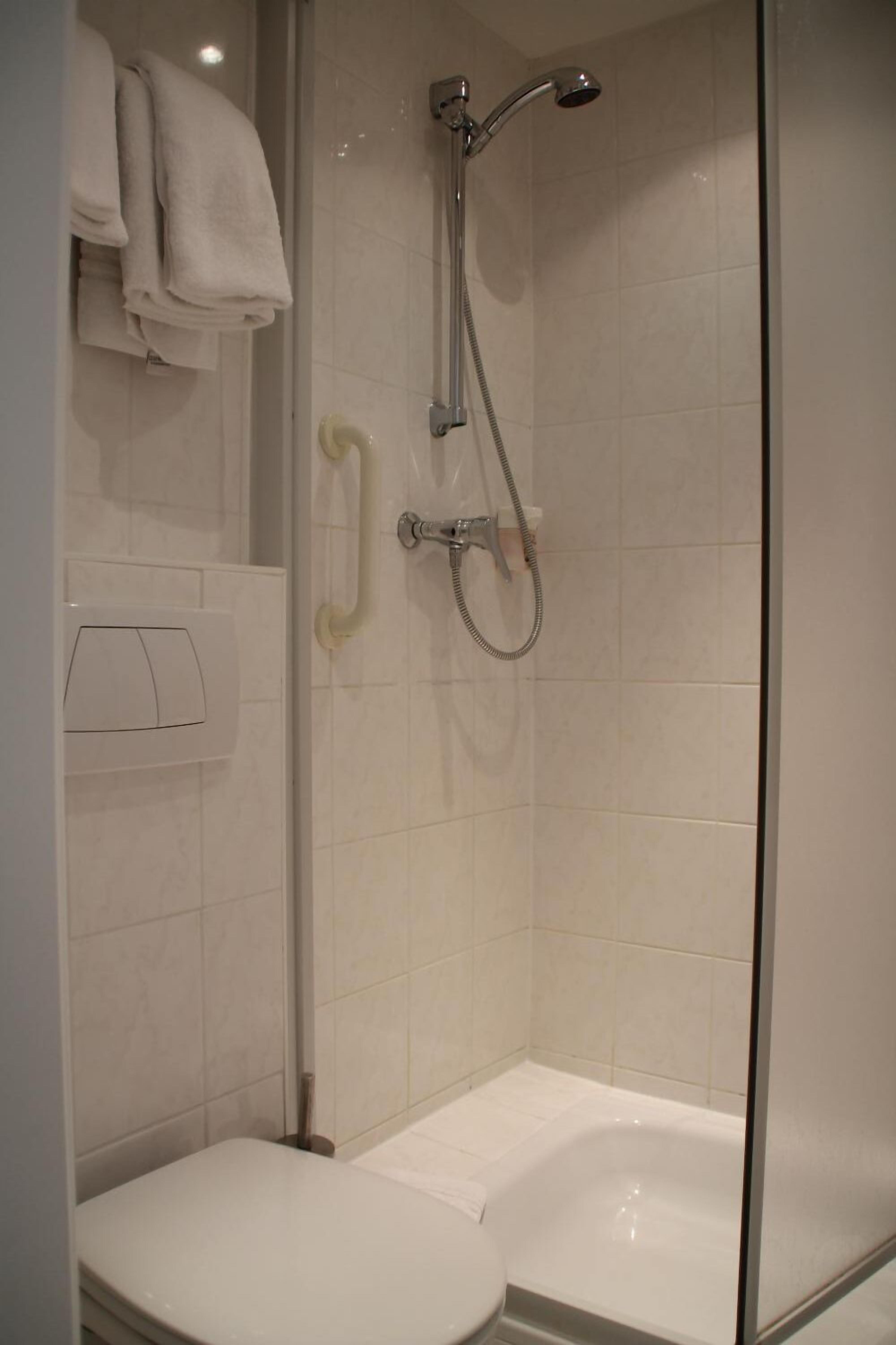 A modern bathroom with a toilet, a shower, and a bathtub.