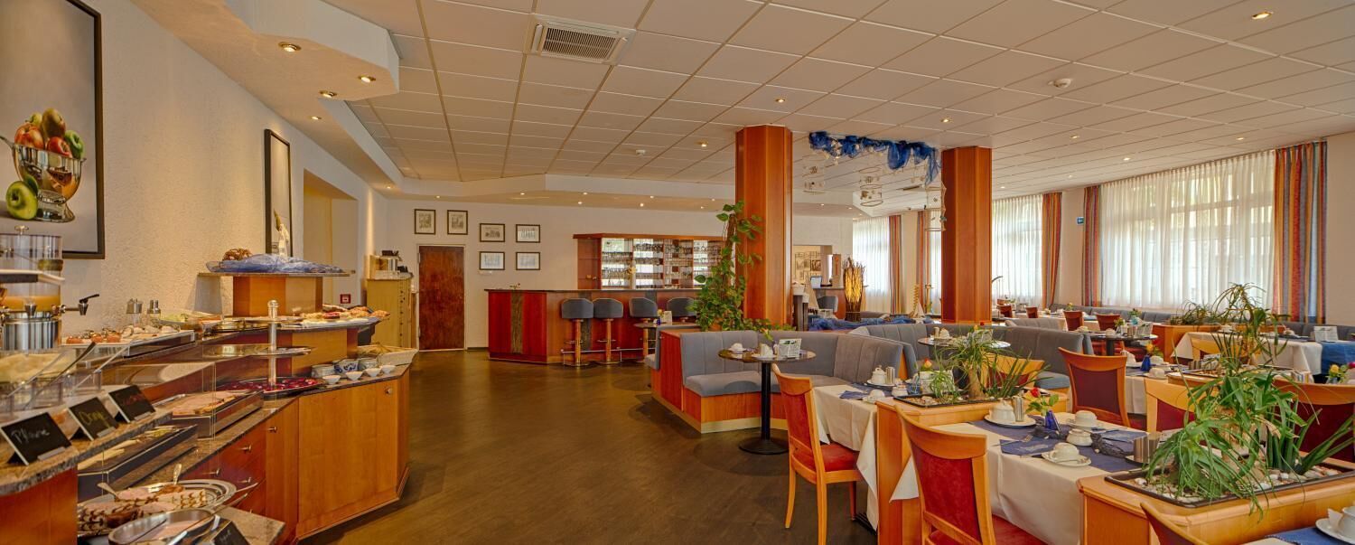 A hotel lobby with a buffet, seating areas, and a bar.