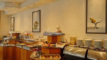 Ein reichhaltiges Buffet mit verschiedenen Speisen, einem Saftspender und einer Kaffeemaschine.