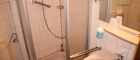 A bathroom with a shower, a sink, and a mirror.