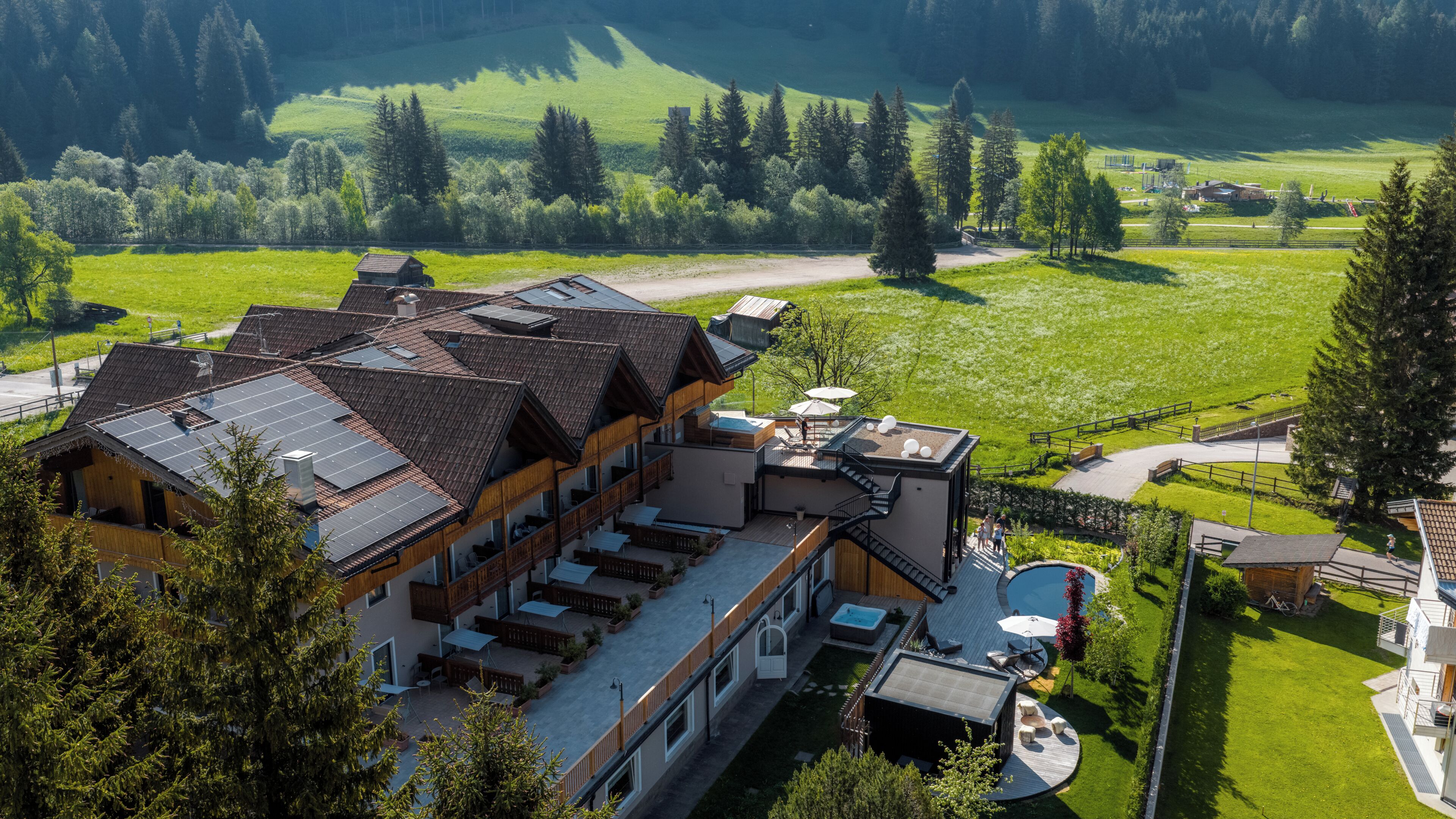 Un moderno rifugio con diverse camere, una piscina e un panorama montano.