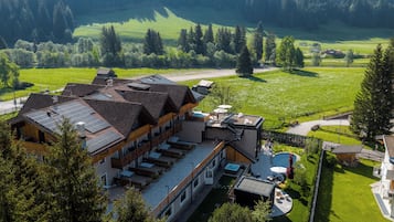 Un moderno rifugio con diverse camere, una piscina e un panorama montano.