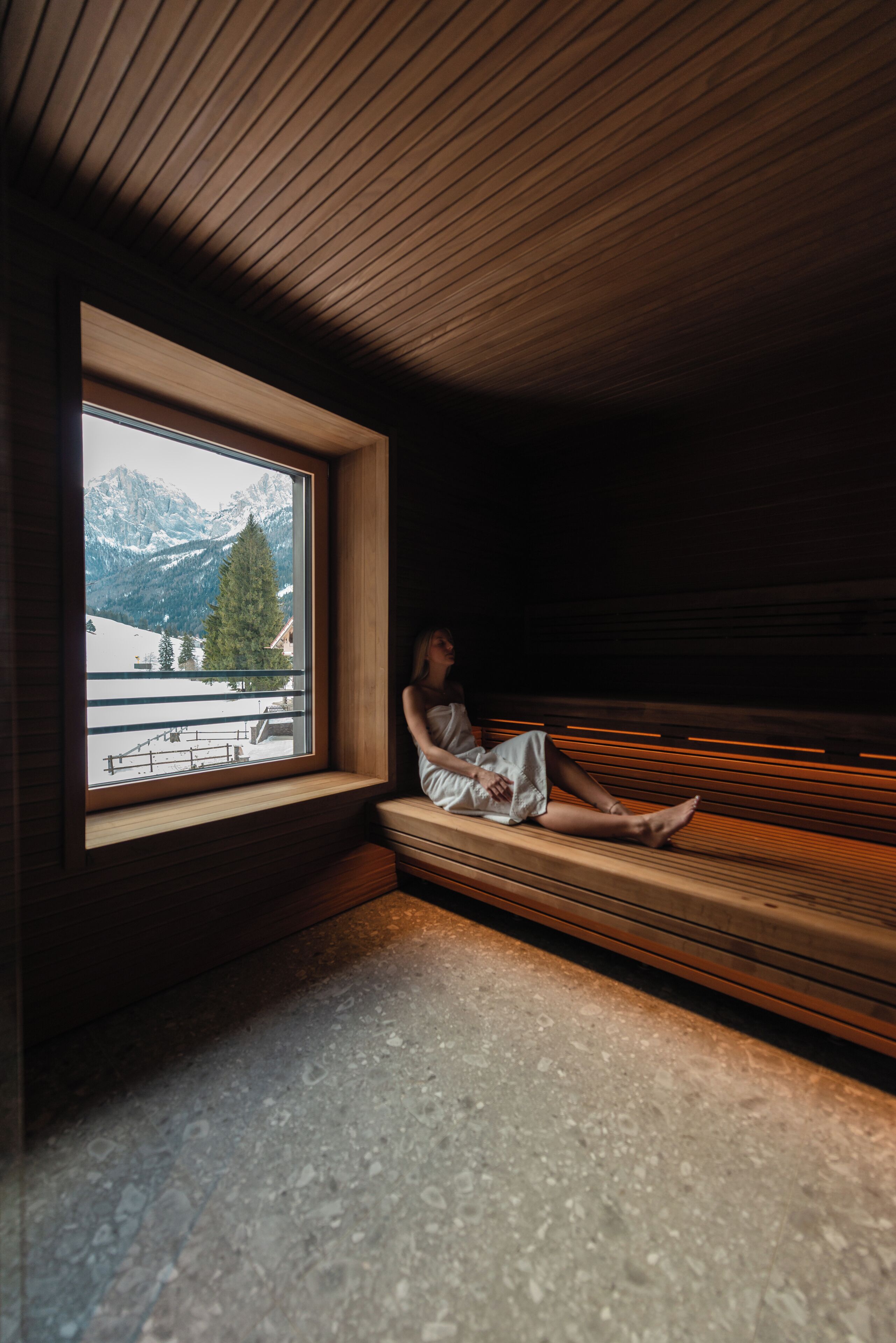 Ein Zimmer mit Holzbalkendecke und einem Fenster mit Blick auf eine verschneite Berglandschaft.
