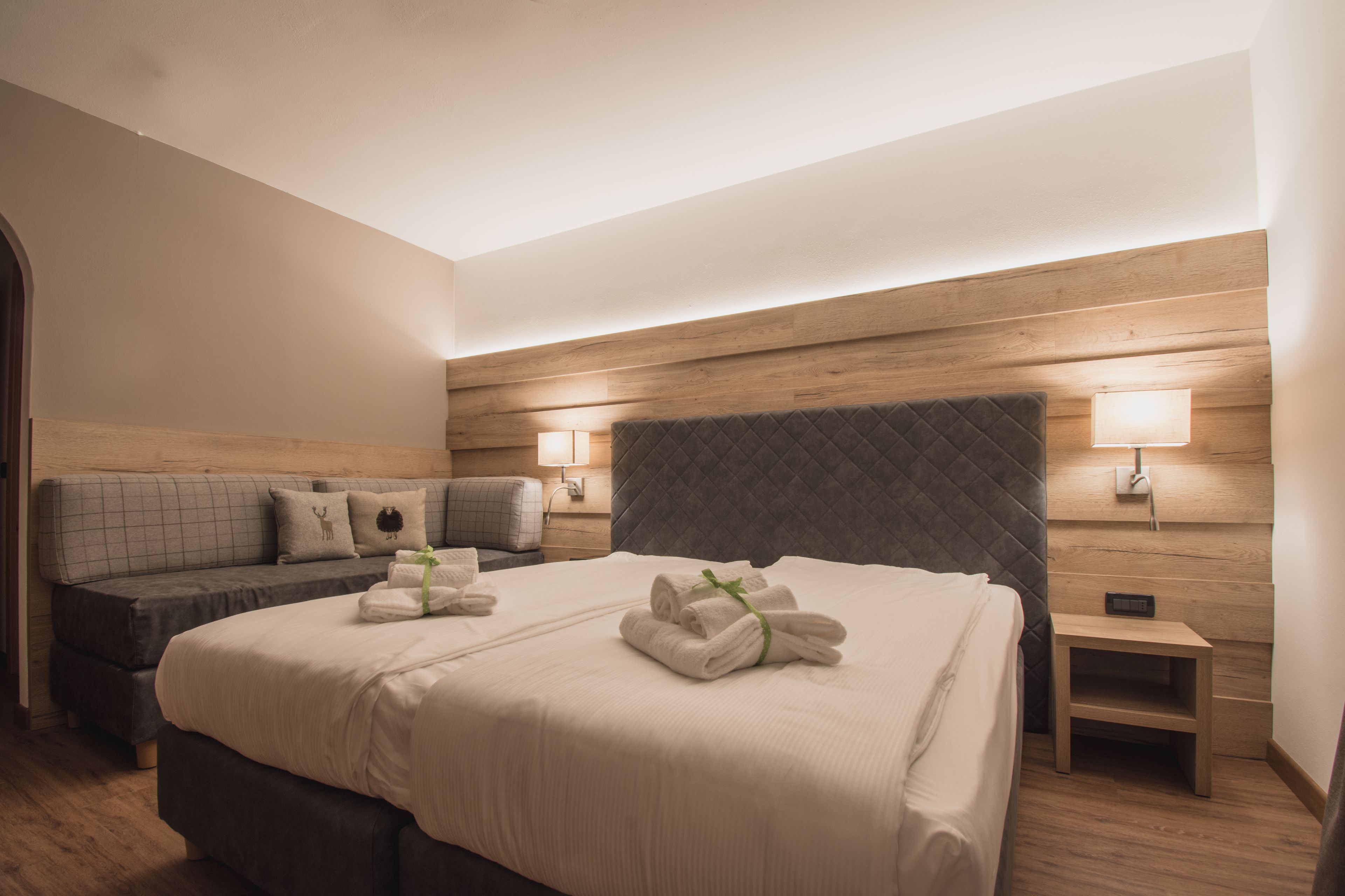 Ein Hotelzimmer mit einem großen Bett, einer Couch, zwei Nachttischlampen und einem Nachttisch.