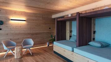 Un interno moderno con pareti in legno, un divano, due poltrone, un tavolino e una sveglia.