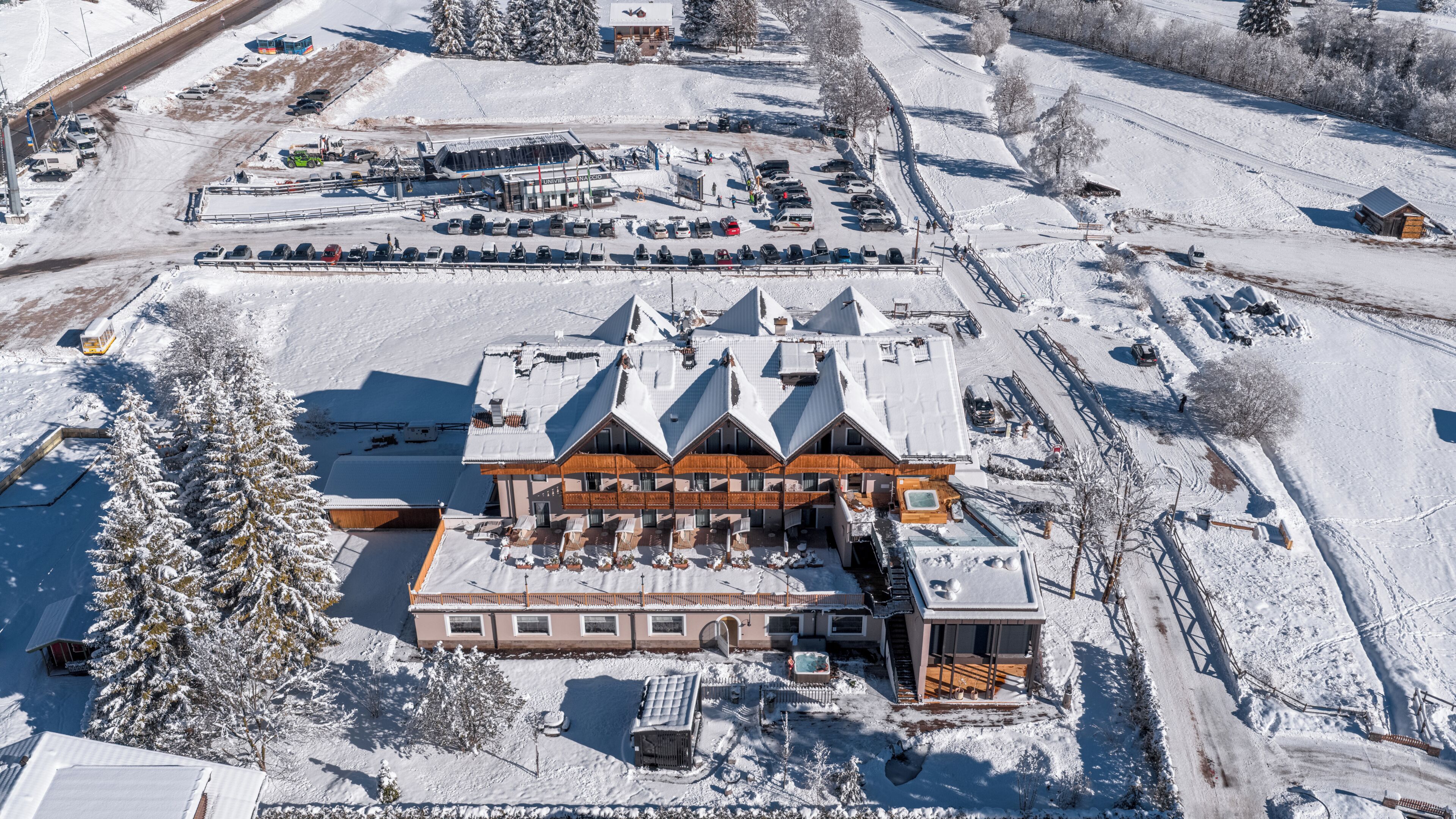 Un gran lodge con varias habitaciones, un telesilla y un área de estacionamiento.