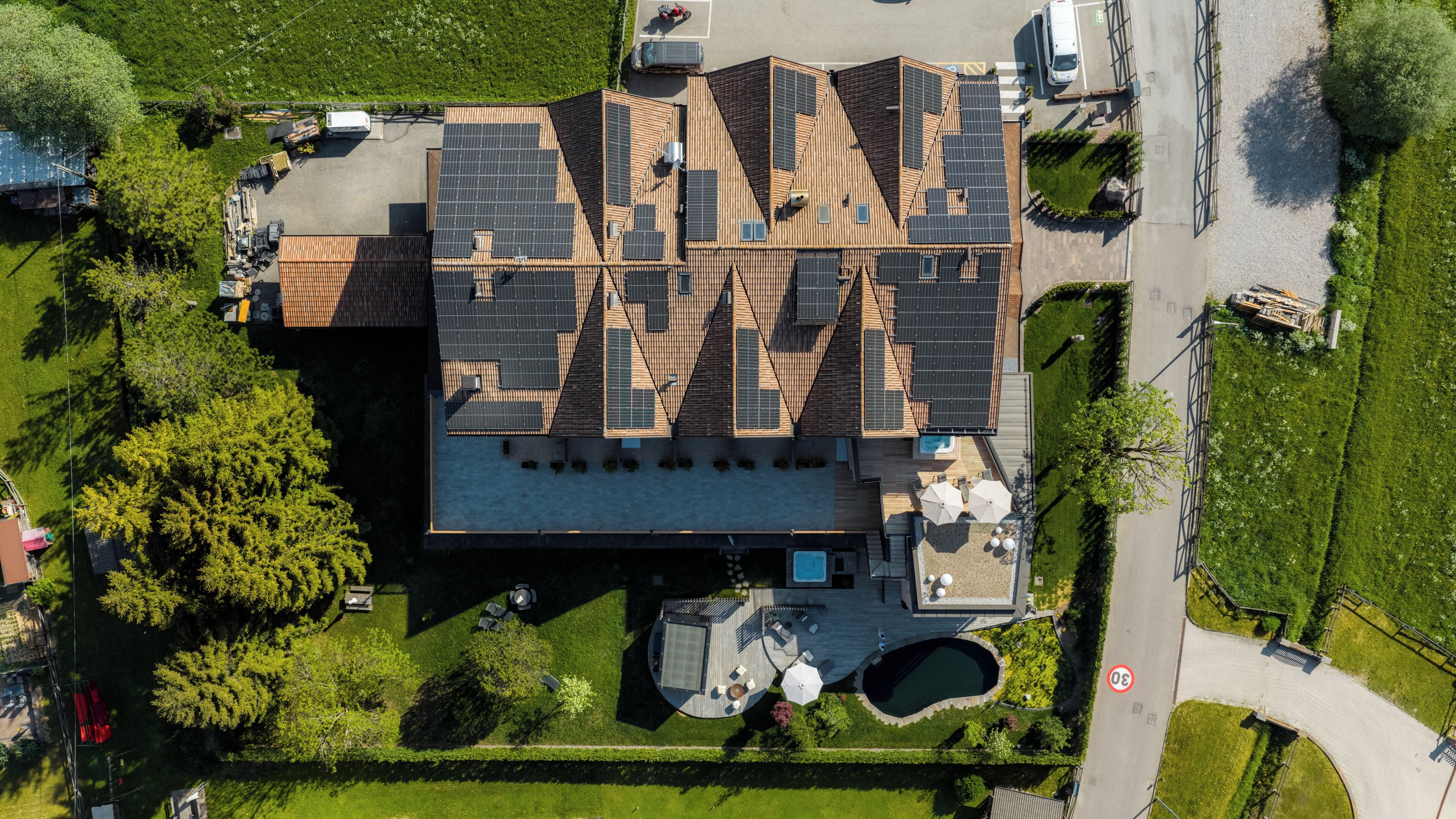 A modern building with a flat roof, solar panels, and a swimming pool.