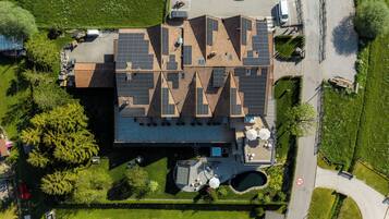Un edificio moderno con techo plano, paneles solares y una piscina.