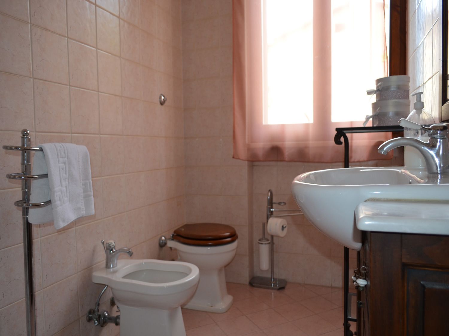 Ein Badezimmer mit Toilette, Bidet, Waschbecken und Handtuchhalter.