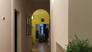 A hallway with a tiled floor, a white radiator, and a potted plant. - Battistero (Florence)