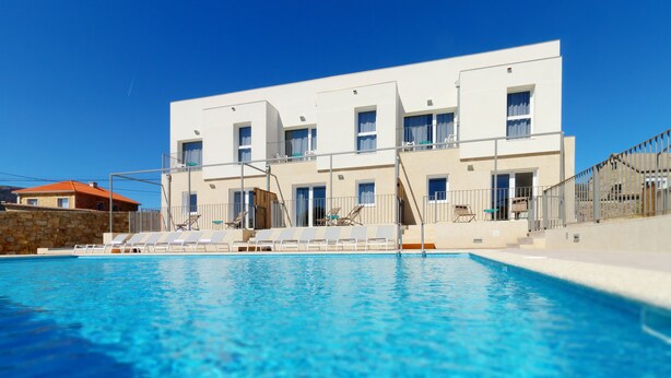 Un edificio moderno con una piscina delantera.