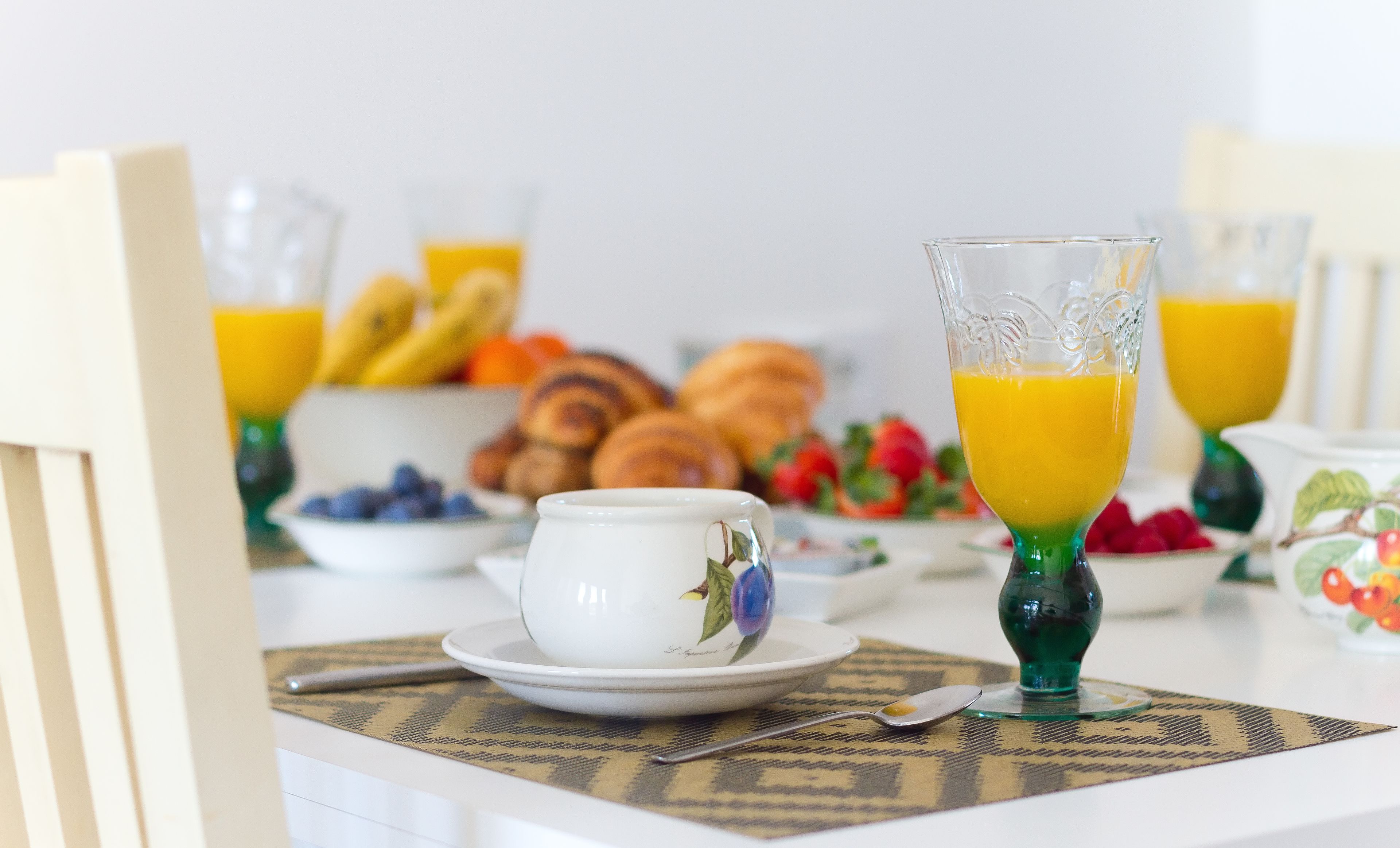 A breakfast setting with croissants, blueberries, and orange juice.