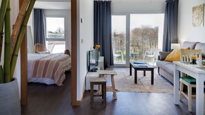 Una sala de estar moderna con una cama, un sofá, un televisor y un comedor.