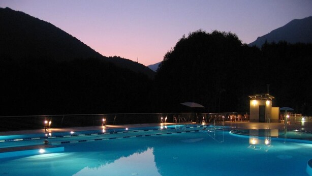 A swimming pool with multiple lanes and a changing room area, surrounded by mountains. - Campeggio Valle Gesso (Entracque)