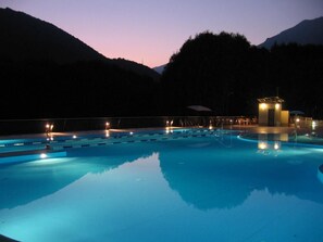A swimming pool with multiple lanes and a changing room area, surrounded by mountains. - Campeggio Valle Gesso (Entracque)