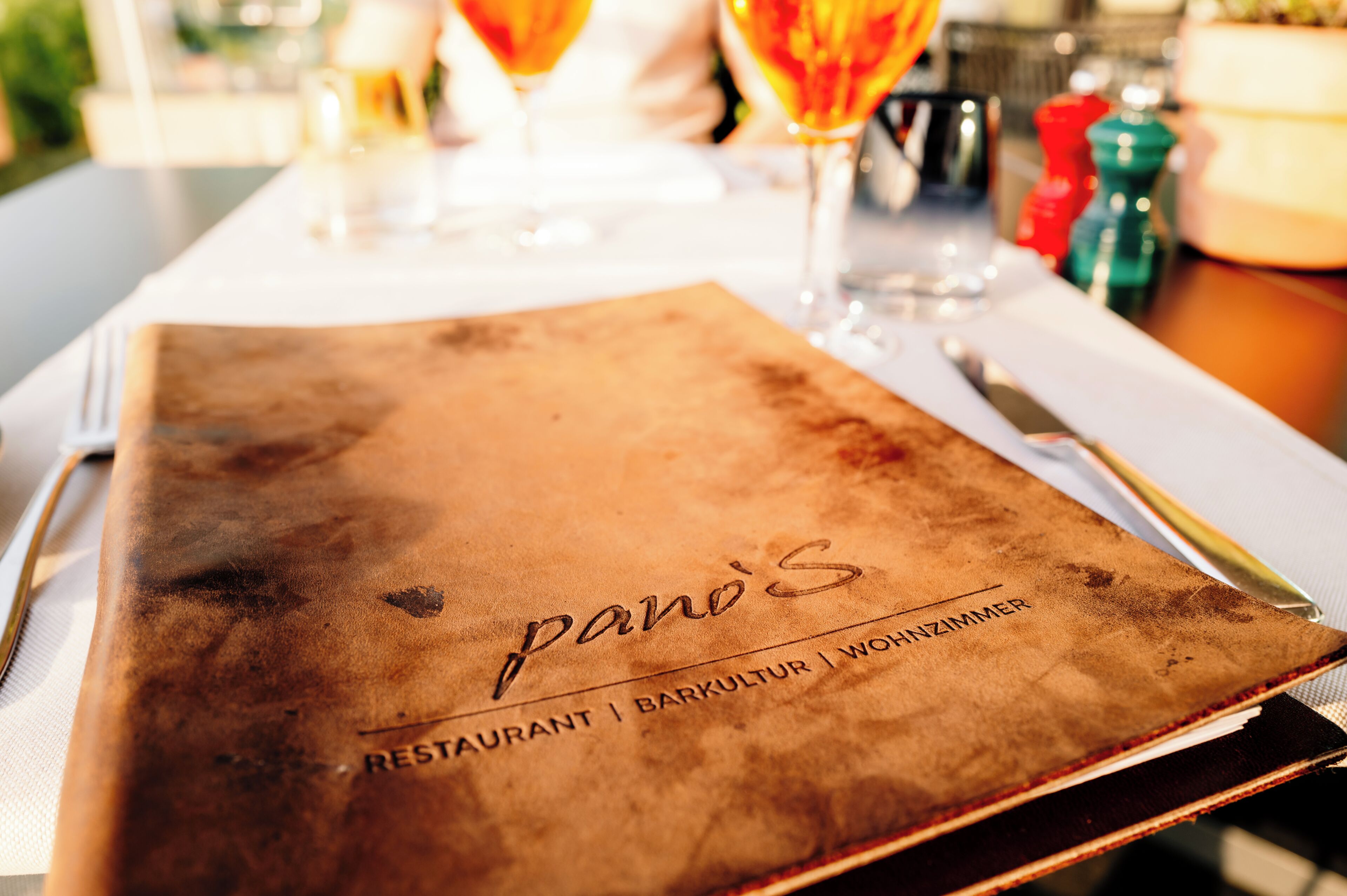 Eine Speisekarte mit geprägtem Text für 'Pano's Restaurant | Barakultur | Wanzimmer'.