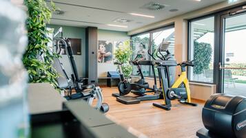 A gym with cardio machines, a treadmill, and a stationary bike.
