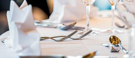 A table set with silverware and a wine glass.