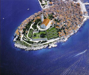 An aerial view of a coastal town with a central square, a prominent church, and a fortified area with a moat. - Guest House Marica (Rovinj)