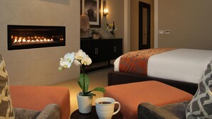 Ein Hotelzimmer mit Kamin, einem Bett, einer Couch und einem Couchtisch.