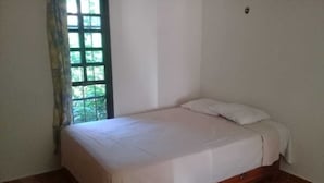 A single bed with a wooden frame and a white mattress in a room with tiled flooring. - Casa Candil, cozy and intimate Mayan corner (Pixoy)