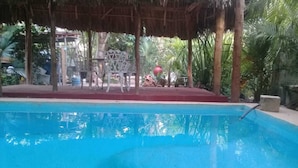 A swimming pool with a thatched roof structure and a red border. - Casa Candil, cozy and intimate Mayan corner (Pixoy)