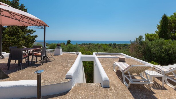 A rooftop terrace with outdoor seating, a pergola, and a view of the sea. - Pajara Annelies (Salve)