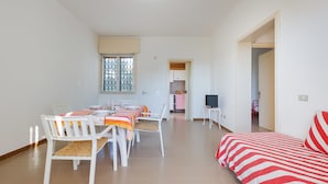 Una habitación amplia con comedor, cama y televisor.