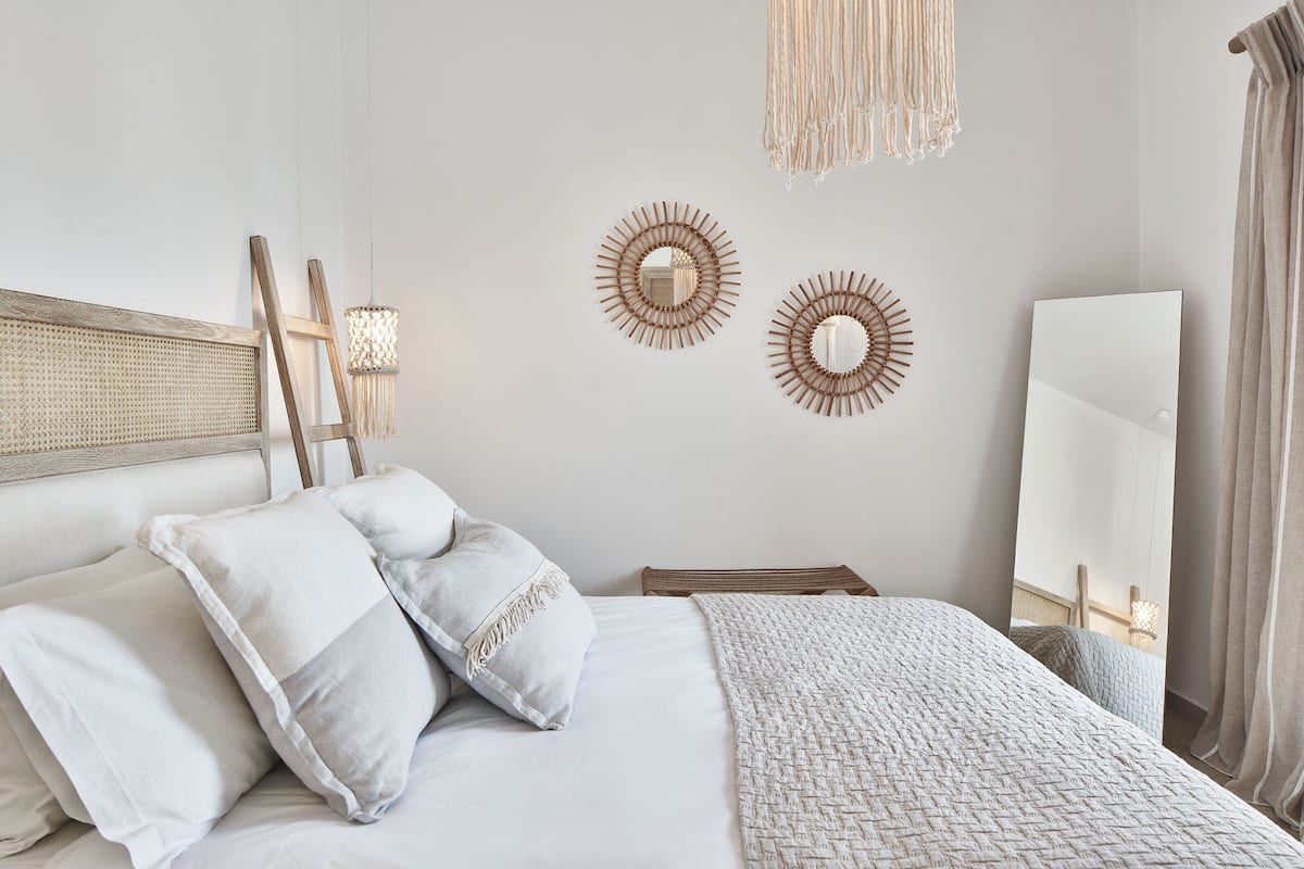 A neatly arranged bedroom with a bed, bedside tables, and wall decor.