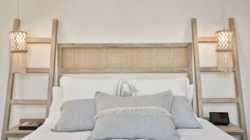 A bed with a wooden headboard, two bedside tables, and two wall-mounted lamps.